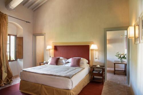 a bedroom with a large bed with two tables and two lamps at Viesca Toscana Suites & Villas in Reggello