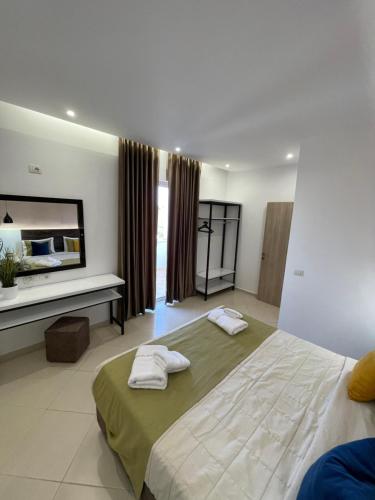 a bedroom with two beds with towels on them at Relax Apts Saranda in Sarandë
