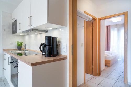 uma cozinha com um lavatório e comodidades para preparar café num balcão em Gorch-Fock Park 2 em Timmendorfer Strand