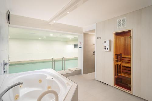 uma casa de banho com uma grande banheira branca num quarto em Hotel Haus am Park em Borkum