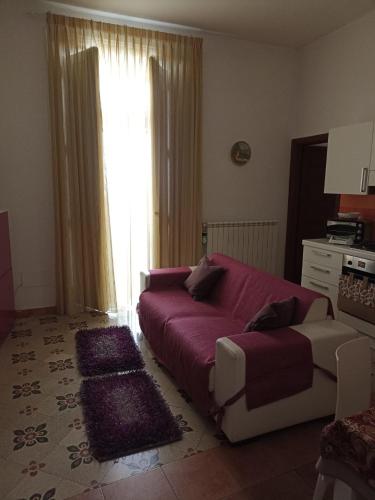 un soggiorno con un grande letto rosso e un divano di Bella Mbriana casa vacanze a Vietri