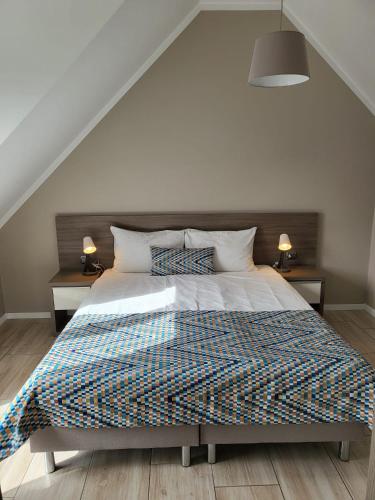 a bedroom with a large bed with two night stands at Kamienica Mielno in Mielno