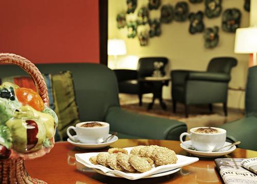 a table with two cups of coffee and some pastries at Hotel Gran Duca Di York in Milan