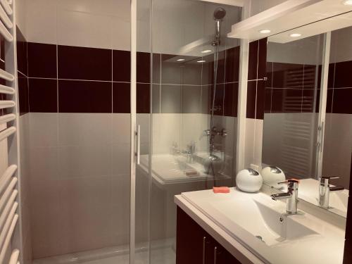 une salle de bain avec un lavabo et une douche en verre dans l'établissement Standing, luminosité à 100m de la mer, T3 prestige, à Saint-Hilaire-de-Riez