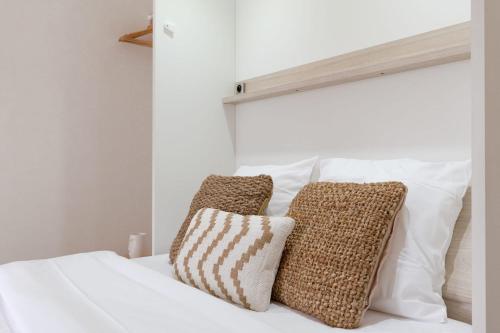 un lit blanc avec deux oreillers dessus dans l'établissement Travel Homes - Grand Rue, Petite Venise - Compact & Cosy - Lit mural, à Colmar