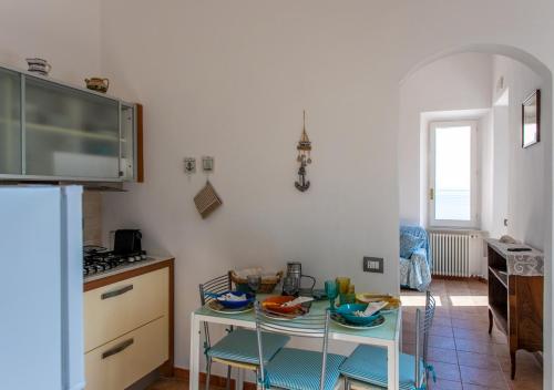 a kitchen with a table with chairs and a counter top at Casa Alessia in Porto Santo Stefano