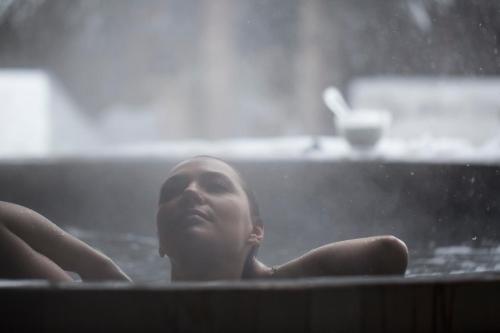 a woman is sitting in a pool of water at Hôtel des Dromonts by SOWELL COLLECTION in Avoriaz