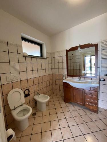 a bathroom with a toilet and a sink and a mirror at Pietrabianca Country House in Manocalzati