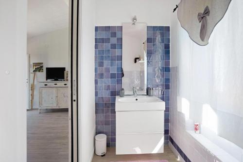 baño con lavabo blanco y azulejos azules en Rosadimaggio Violetta, en Arcola