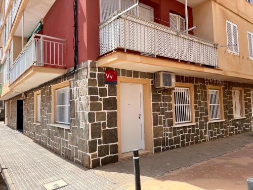 a brick building with a white door and a balcony at Cabo de palos subida al faro in Cabo de Palos