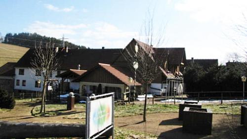 ein Schild vor einer Gruppe von Häusern in der Unterkunft Daumsmuhle in Mossautal