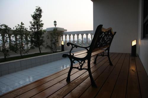 a bench sitting on a wooden deck looking out at a balcony at Golden Tulip - Aesthetics in Zhunan