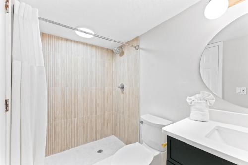 a bathroom with a shower and a toilet and a sink at Cocoa Beach Club in Cocoa Beach