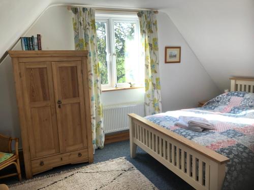 Schlafzimmer mit einem Bett und einem Fenster in der Unterkunft Little Glebe in Sherborne