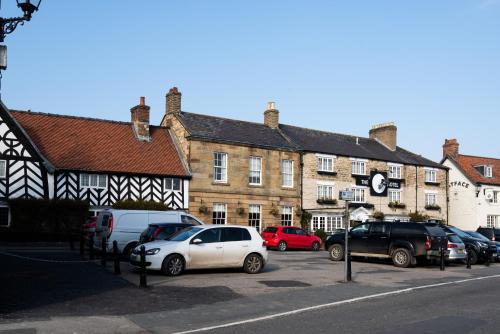 a group of cars parked in front of a building at The Black Swan - The Inn Collection Group in Helmsley