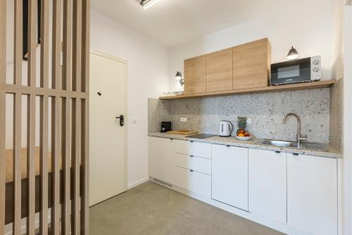 a kitchen with white cabinets and a sink at PORTO SERENO apartments in Šibenik