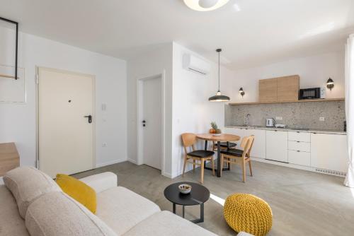 a white living room with a couch and a table at PORTO SERENO apartments in Šibenik