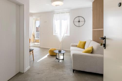 a white living room with a couch and a table at PORTO SERENO apartments in Šibenik