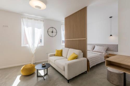 ein Wohnzimmer mit einem Sofa und einem Tisch in der Unterkunft PORTO SERENO apartments in Šibenik