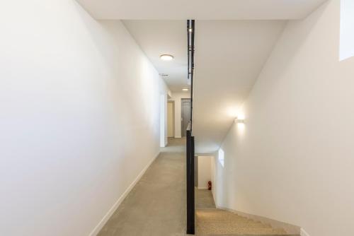 a hallway with white walls and a black pole at PORTO SERENO apartments in Šibenik