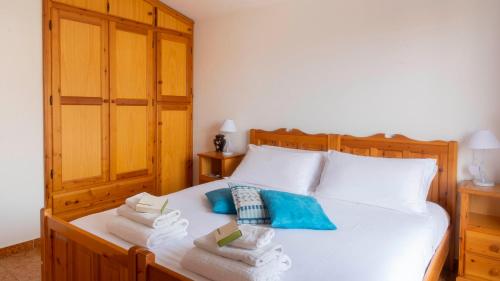 a bedroom with a white bed with towels on it at Casa dei Lentischi in Cala Gonone