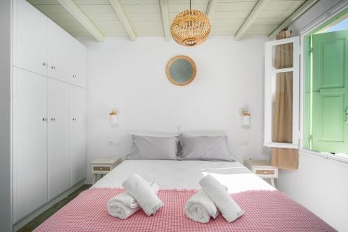 a white bedroom with a bed with towels on it at SERIFOS BELLA VISTA 1 in Livadi