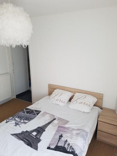 un lit avec deux oreillers blancs dessus dans l'établissement Le Tréport vue sur mer et sur l entrée du port, au Tréport