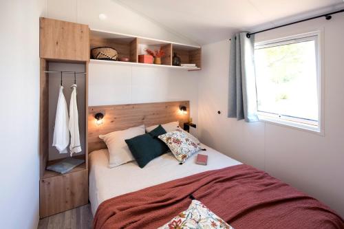 a bedroom with a large bed with a window at Camping Le Rey in Louvie Juzon