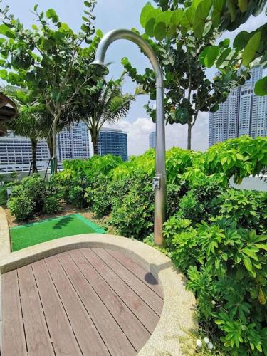 a wooden boardwalk in a park with trees and a street light at MUJI STYLE STUDIO Almas 100mbps Pool View Netflix By STAY in Nusajaya