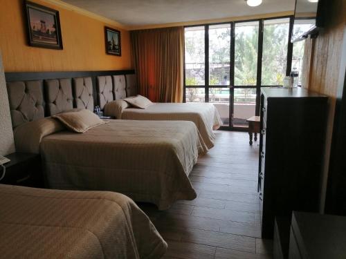 Una cama o camas en una habitación de Hotel Las Américas