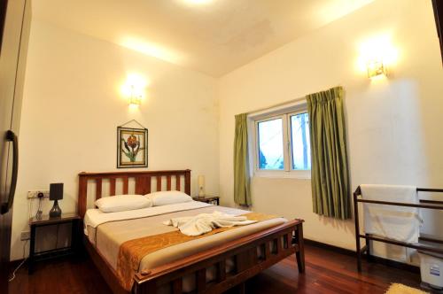 een slaapkamer met een bed en een raam bij Clouds Holiday Bungalow Haputhale in Haputale