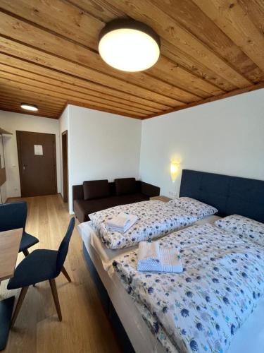 a bedroom with a large bed and a couch at Pension Sommerauer in Hallein
