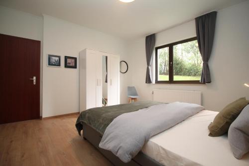 歐本的住宿－Oscappart，一间卧室设有一张大床和一个窗户。