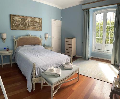 a bedroom with blue walls and a bed with a bench at Casa Delft in Furnas