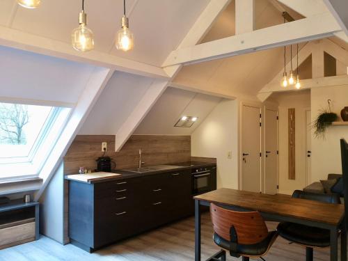 an attic kitchen with a table and a dining room at Vakantieverblijf Volmolen B&B in Maaseik
