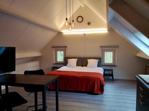 a bedroom with a bed with a red blanket at Vakantieverblijf Volmolen B&B in Maaseik