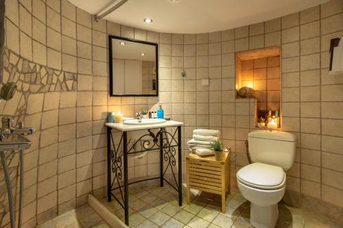 W łazience znajduje się toaleta, umywalka i lustro. w obiekcie Anemomylos-Windmill w mieście Ermupoli