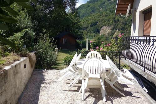 eine Gruppe weißer Stühle auf einer Terrasse in der Unterkunft Villa 180 m² proche 3 vallées et station thermale in Champoulet