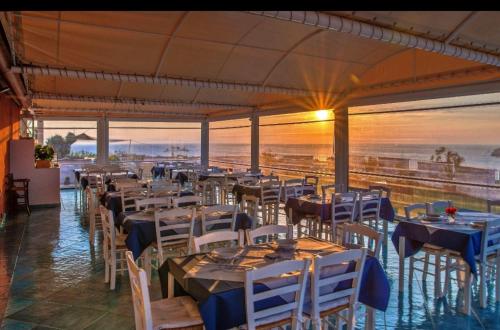 a restaurant with tables and chairs with a view of the ocean at Hotel Borgo Cacciatori in Ventotene