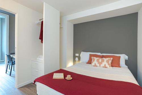 a bedroom with a large white bed with a red blanket at Suite Brunate - by MyHomeInComo in Como