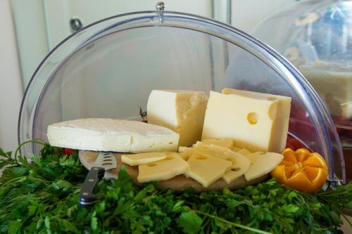 a glass plate with cheese and other cheeses and greens at Terrazza Marconi Hotel&Spamarine in Senigallia