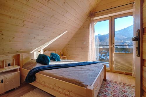 a bedroom with a bed with a large window at Domki na Skałach Centrum Zakopane in Zakopane