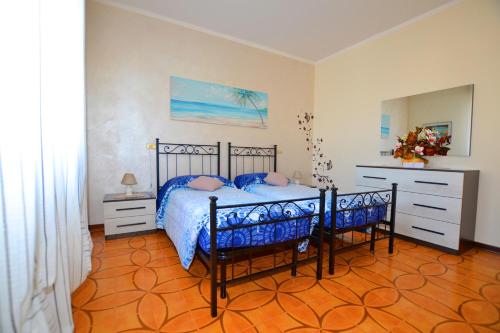 a bedroom with a bed with blue comforter and a dresser at Casa Patty in Sirmione