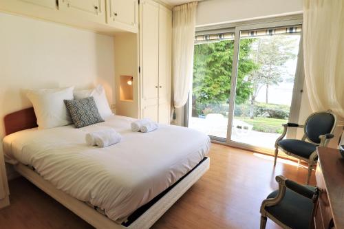 1 dormitorio con cama y ventana grande en MAISON DU GOLFE, en Séné