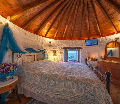 1 dormitorio con cama y techo de madera en Anemomylos-Windmill, en Ermoupoli