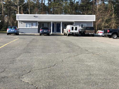 a parking lot with cars parked in front of a building at Rosewood Motel in East Wareham