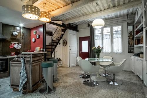 een keuken met een tafel en stoelen in een kamer bij La Chineuse - maison de charme in LʼIsle-sur-la-Sorgue