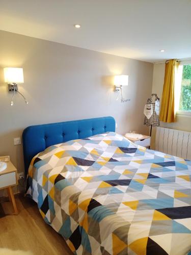 a bedroom with a blue bed with a colorful comforter at Maison d'une chambre avec terrasse amenagee et wifi a Embreville in Embreville