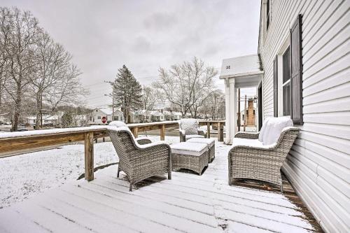 a porch covered in snow with wicker chairs at Modern South Bend Getaway about 3 Mi to Downtown in South Bend