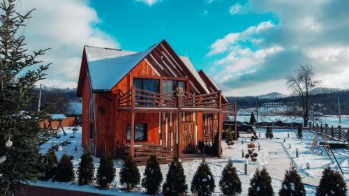 a log cabin in the snow with snow at Four Seasons In Carpathians in Migovo
